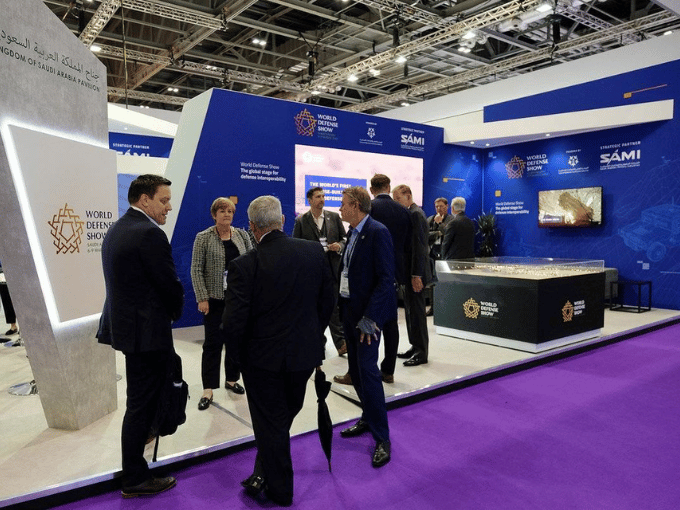 Business professionals networking at the World Defense Show exhibition in Saudi Arabia with premium convention and trade show transportation services
